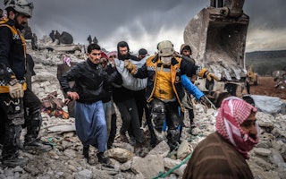 Volunteers help members of the White Helmets rescue someone who was trapped in a collapsed building after a massive earthquake in Idlib, Syria, on February 6, 2023. Photo credit: © Anas Alkharboutli/picture alliance/Getty A group of people carrying an injured person among rubble