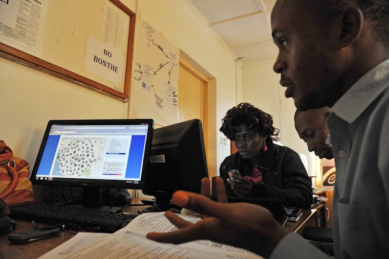 Observers for the National Election Watch at work in Freetown, Sierra Leone, on November 16, 2012. Photo credit: © Issouf Sanogo/AFP/Getty Two election observers in Sierra Leone check a computer with live data from a polling station.