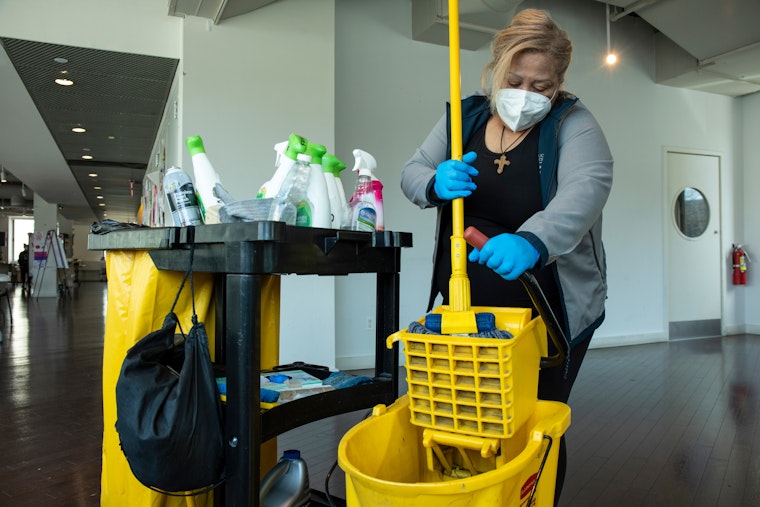 An undocumented essential worker who received pandemic related support from Catholic Charities in New York City on March 19, 2021. © Ed Kashi/VII for the Open Society Foundations A woman wring a mop into a bucket