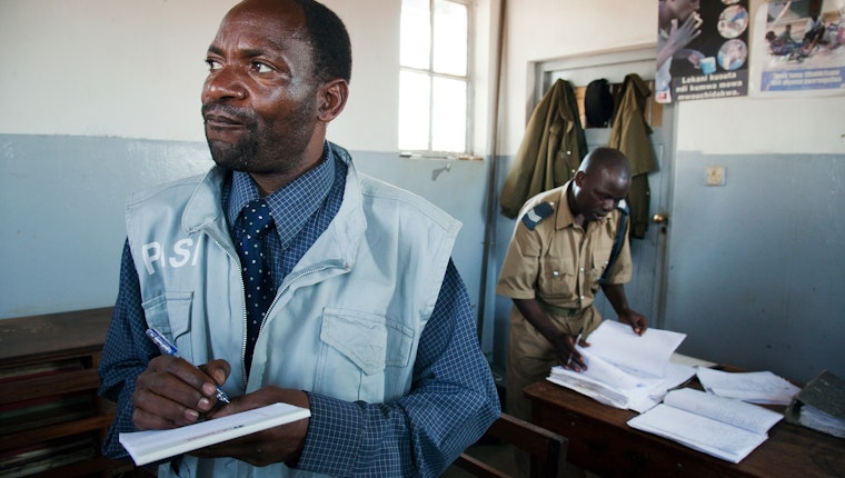 A paralegal prepares to meet with a detainee in Lilongwe, Malawi, on August 19, 2010. Photo credit: © Ed Kashi /VII for the Open Society Foundations Two men with paperwork inside a police station