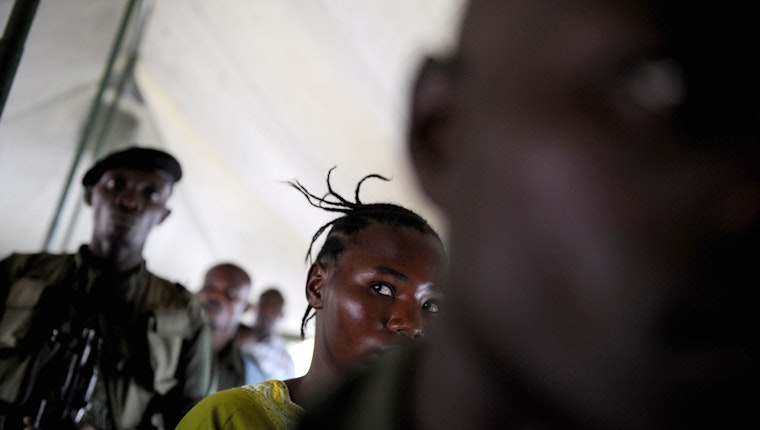 A victim of sexual assault looks at her attacker as he is being sentenced by a military court in Goma, Democratic Republic of the Congo, on November 17, 2008. Photo credit: © Roberto Schmidt/AFP/Getty People in a tent