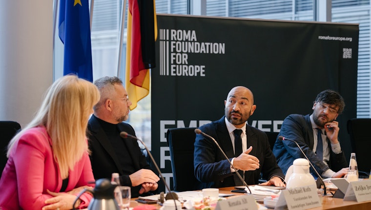 Attendees discuss issues impacting Ukrainian Roma during an event at the German Bundestag. Photo courtesy of the Roma Foundation for Europe Three panel speakers seated in front of a backdrop that says "Roma Foundation for Europe"