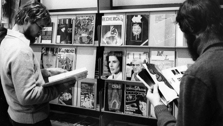 People browsing magazines in front of a rack of periodicals. Photo credit: © Harry Hampel/ullstein bild/Getty People browsing magazines in front of a rack of periodicals