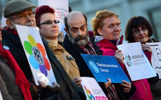 Activists from multiple organizations display their logos during an antigovernment demonstration in front of the Hungarian parliament, in Budapest, on February 5, 2017. Photo credit: © Atilla Kisbenedek/AFP/Getty A row of people holding signs